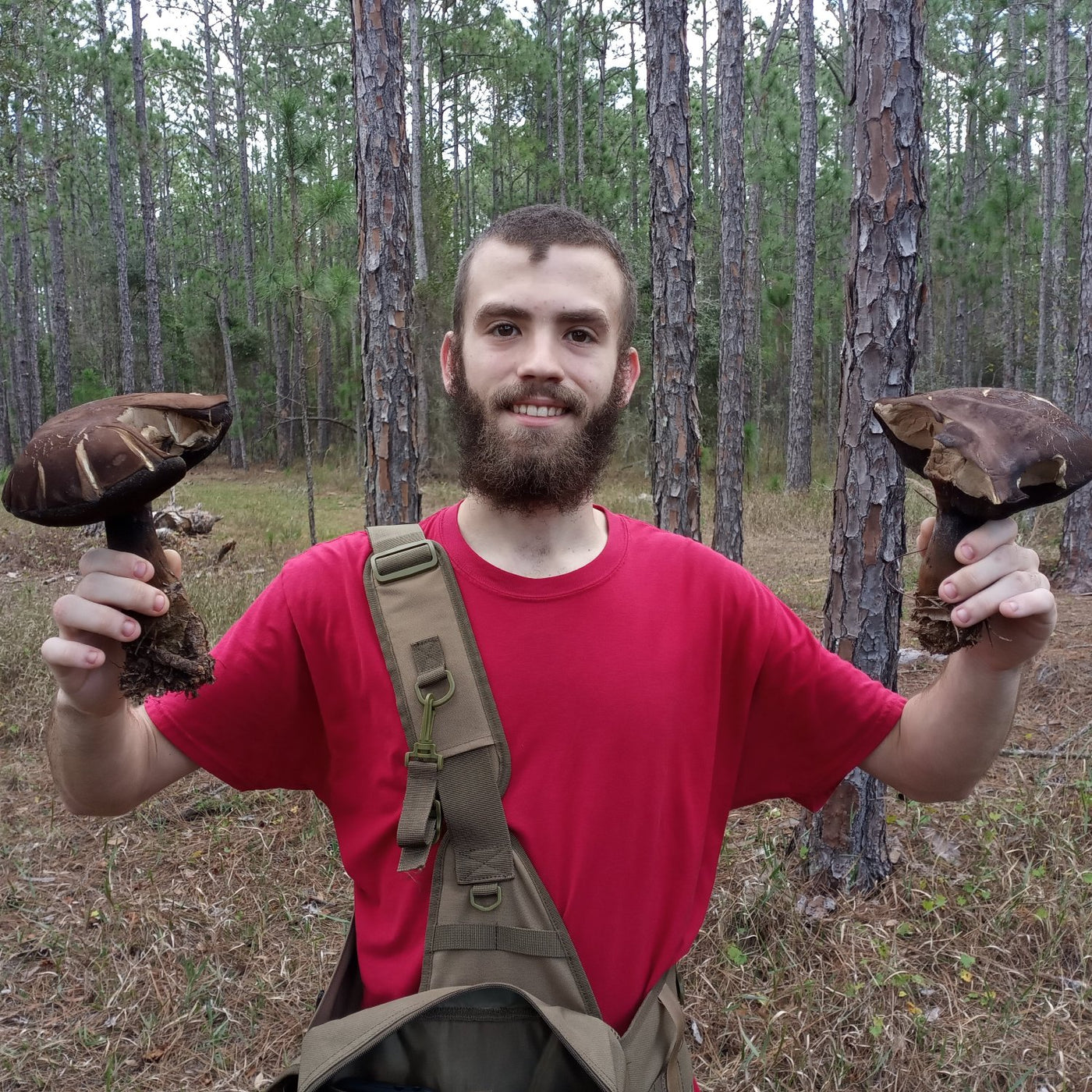 julian mazer lead mycologist at liquid fungi holding two forged bolete mushrooms